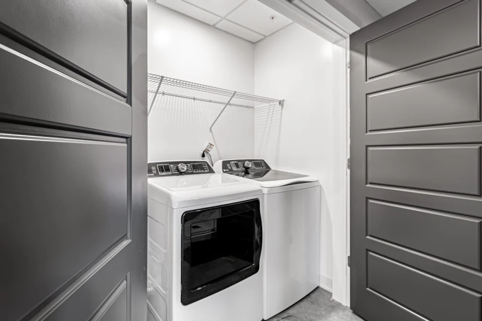 In-unit laundry room with a seamless floor beneath washer and dryer