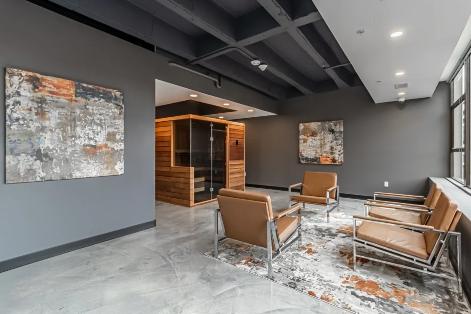 Amenity lounge seating on a seamless FlowStone floor with a cedar sauna beyond